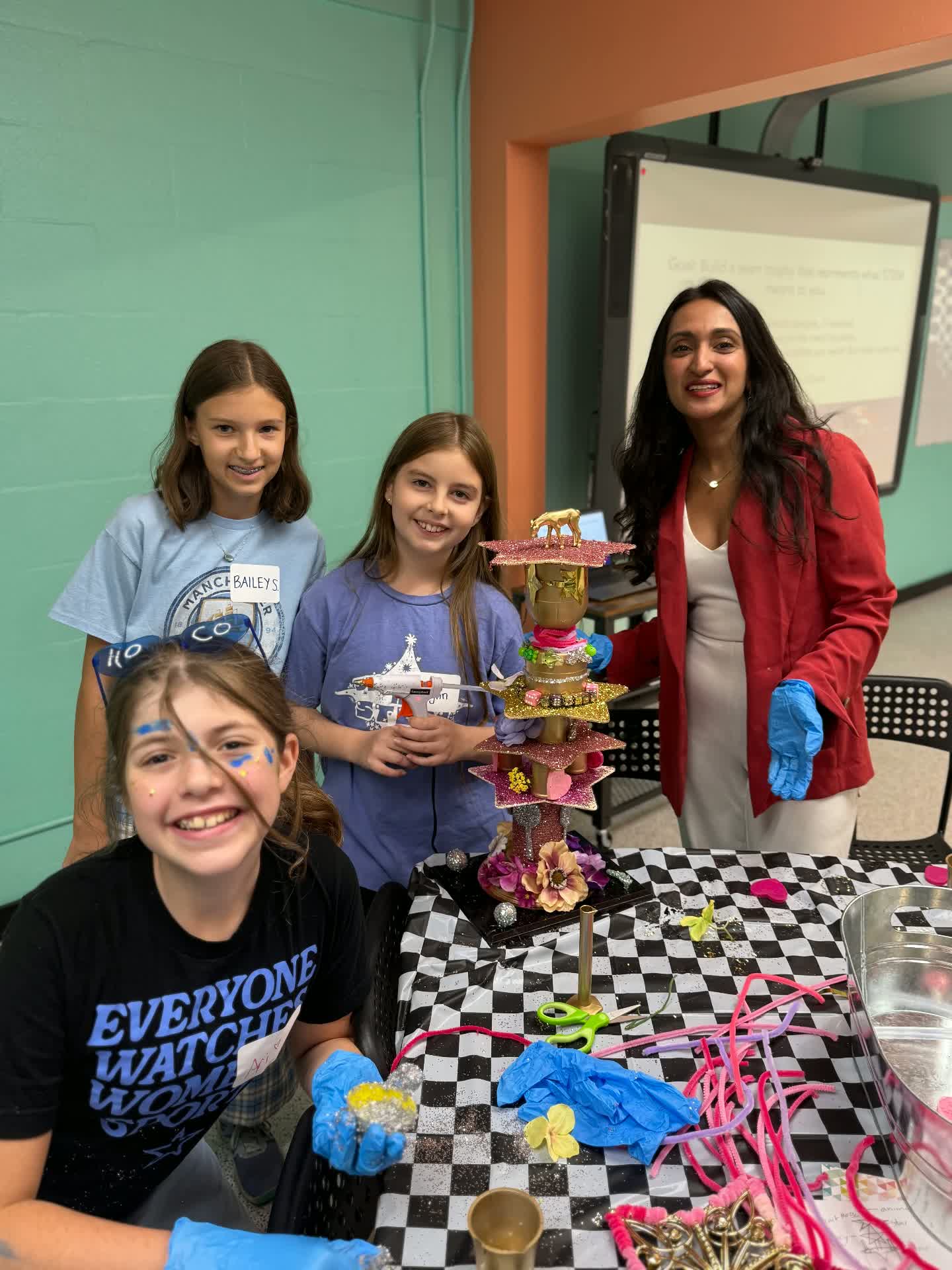 Girls building a STEM trophy with a mentor
